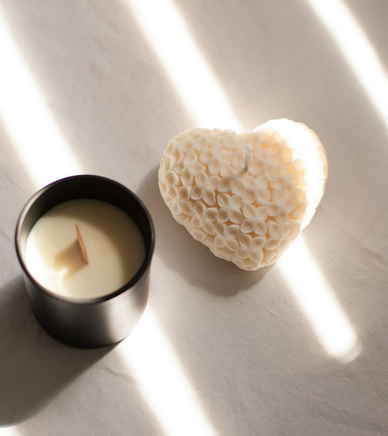 Photo by Ionela Mat A candle with a heart shaped candle holder next to it